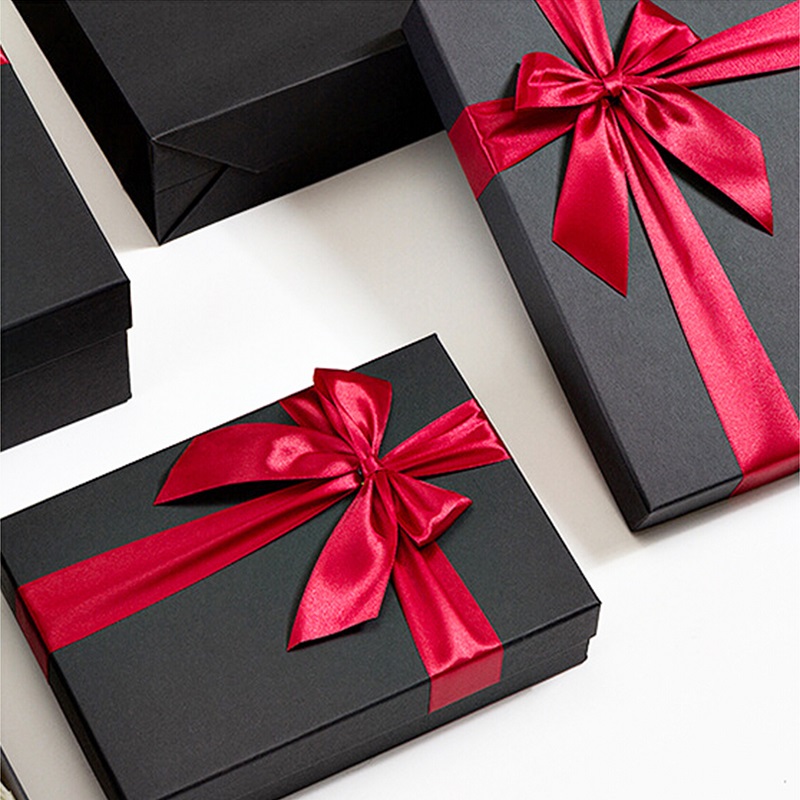 Cajas de regalo decoradas con cinta negra. Cartones marrones
